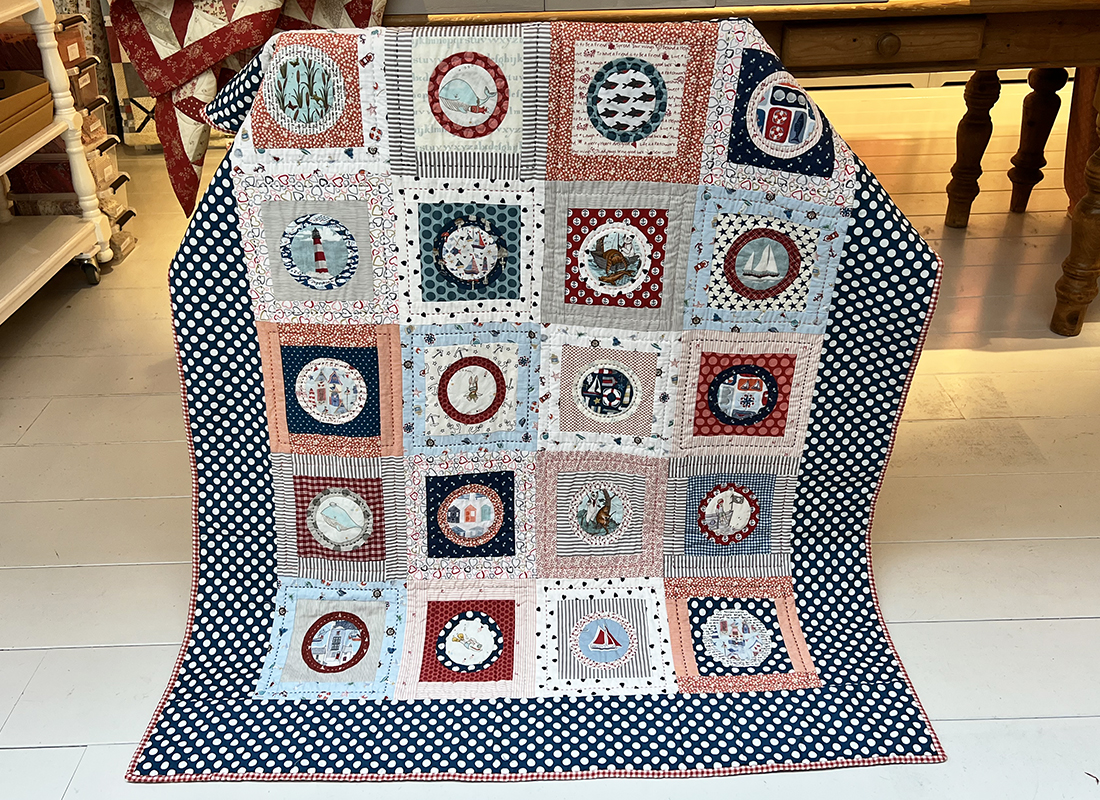 Anita bracht deze gezellige 'zeestofjes' quilt mee naar onze winkel.Wat een leuk idee om verschillende plaatjesstofjes op deze manier te verwerken! Echt een stoer quiltje.....