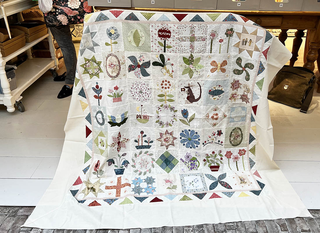 Bij Quilt Studio het Gooi komen vaak quiltvriendinnen winkelen. Gezellige een dagje uit en aansluitend een lunch in onze dorpsherberg. Dineke kwam met haar quiltclubje shoppen en een achterkant uitzoeken bij deze prachtige miniversie van de Stonefields quilt. Kijk eens hoe leuk deze rand is! Ze heeft de Flying Geese van het oorspronkelijke ontwerp gekanteld. Wat een idee..... Alle aanwezige klanten in de winkel hebben even meegenoten van deze vrolijke quilt. Dank je wel dat hij op de foto mocht Dineke!