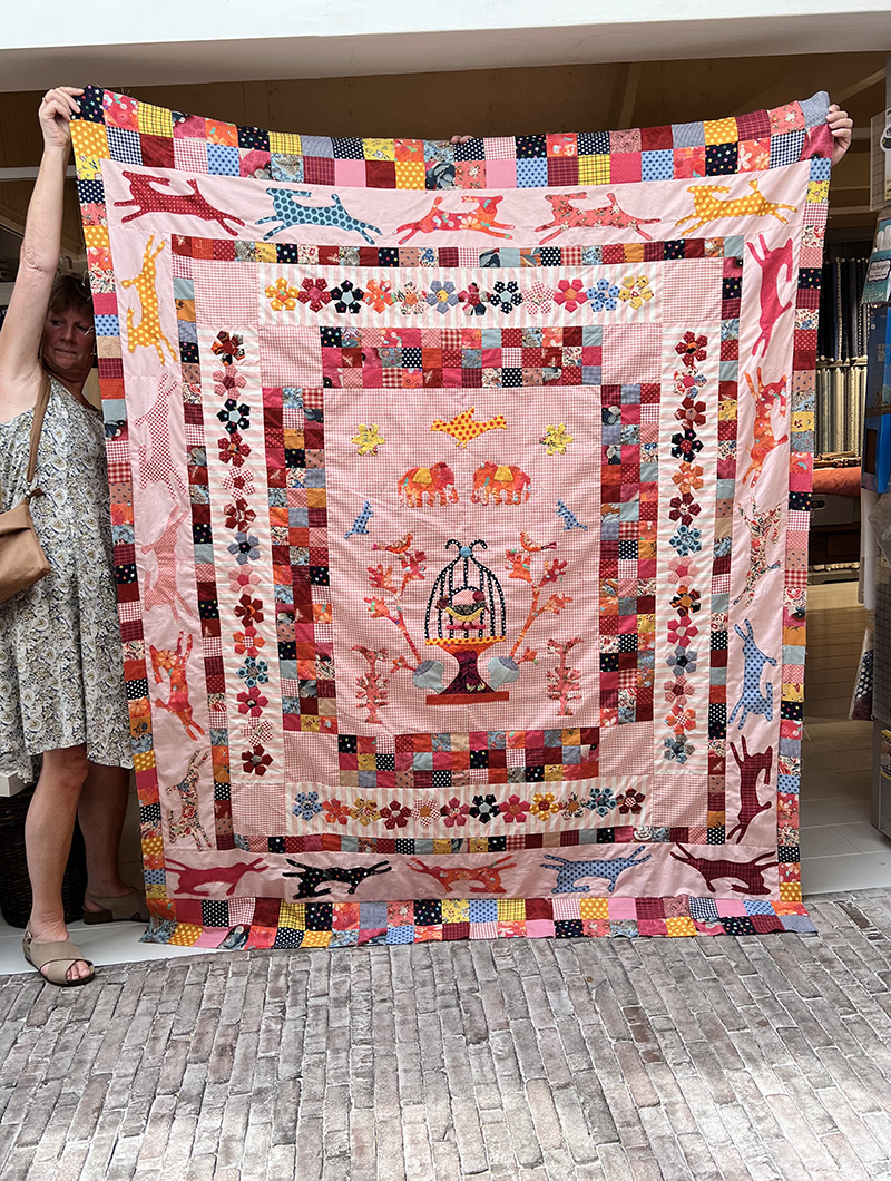 Dicky kwam vandaag een achterkant uitzoeken bij deze echt schitterende quilt! De inspiratie haalde ze uit een Quiltmania boek van Margaret Sampson George. Ze verzon er zelf diverse randen bij. Het roze kuitstofje had ze al jaren in huis. Maar wat geeft deze de quilt een leuke uitstraling! Echt een plaatje Dicky. Het meisje dat deze gaat krijgen zal er dolblij mee zijn....